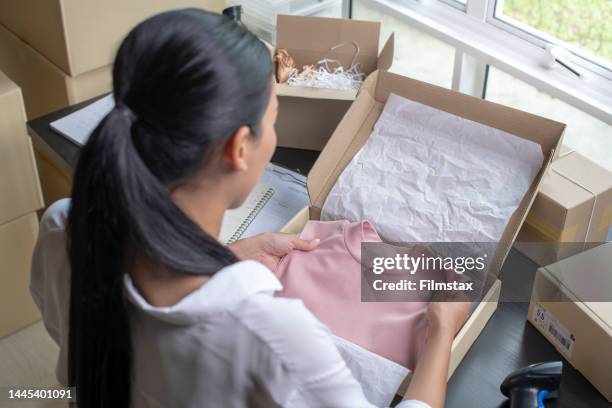 asian woman e-commerce owner packing package post shipping box preparing delivery parcel on table. - textile for delivery stock pictures, royalty-free photos & images