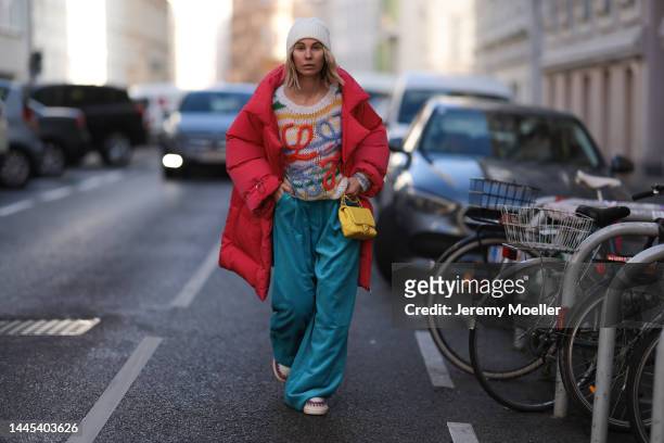 Karin Teigl is seen wearing Chanel yellow leather bag, Loewe knit logo colorful striped sweater, Essential Antwerp oversized blue cord pants, Chanel...