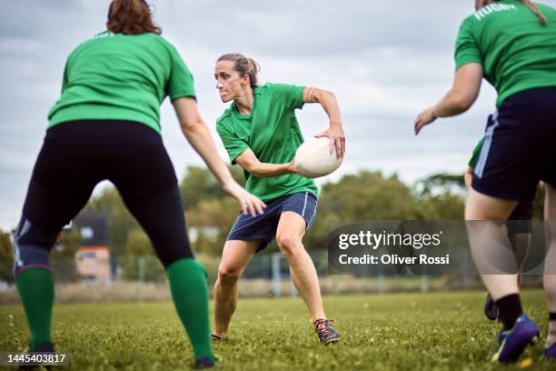 women playing rugby on sports field - women's rugby stock-fotos und bilder