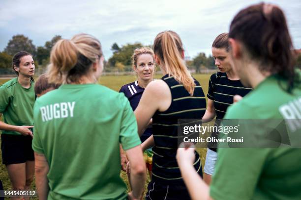 women's rugby team talking on sports field - rugby pitch stock pictures, royalty-free photos & images