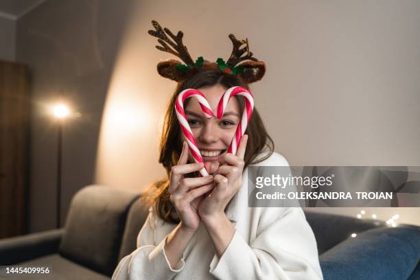 young woman with red christmas candy sticks in heart shape - 18 23 monate stock-fotos und bilder