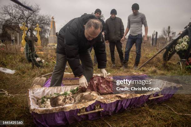 Forensic expert, Doctor Ihor Motrich inspects the body of a 16-year-old girl that was exhumed by local residents, police, forensic experts and war...