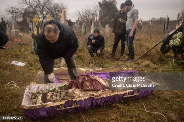 Forensic expert, Doctor Ihor Motrich inspects the body of a 16-year-old girl that was exhumed by local residents, police, forensic experts and war...