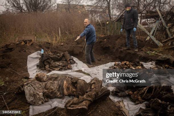 Forensic expert, Doctor Ihor Motrich looks over the exhumed remains recovered from a burial site containing the bodies of six civilians that were...