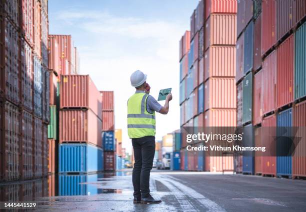 engineer and tablet at containers yard from cargo freight ship for import export - docklands stock pictures, royalty-free photos & images