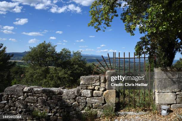 metal garden gate & old stone wall oppede-le-vieux france - stone wall garden stock pictures, royalty-free photos & images