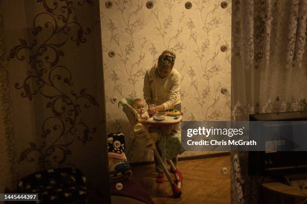 Kherson Regional Children's Hospital Nurse, Tetiana Pavelko feeds wher adopted daughter Kira at home on November 28, 2022 in Kherson, Ukraine. Kira...