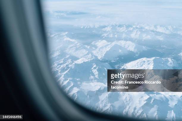 flying over the snowy alps - window seat stock pictures, royalty-free photos & images