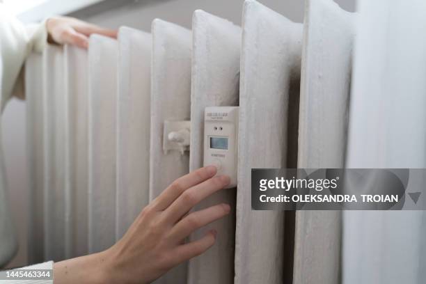 young woman using the home radiator with temperature sensor - temperature sensor stock pictures, royalty-free photos & images