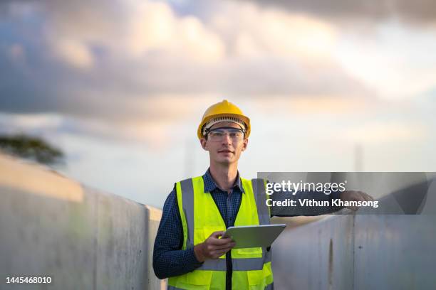 engineer and tablet check quality concrete at heavy construction site. - casco protector fotografías e imágenes de stock