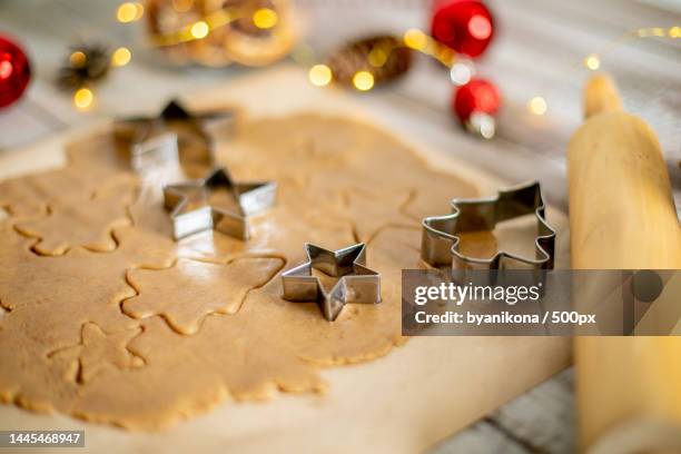 raw dough for cookies,cookie cutters and festive decoration on wooden table christmas sweet food,kazakhstan - formine foto e immagini stock