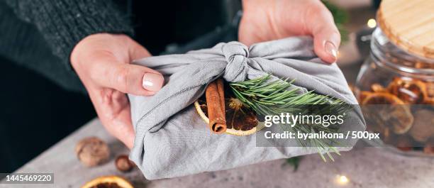 woman holding wrapped gift in fabric with green branch,organic decoration banner image,kazakhstan - kazakhstan food stock pictures, royalty-free photos & images
