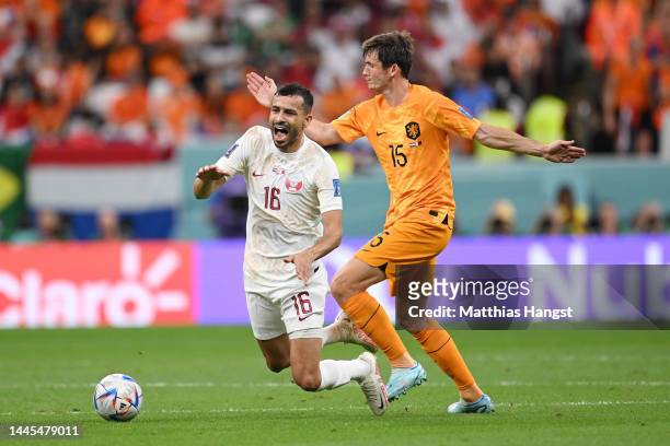 Boualem Khoukhi of Qatar is challenged by Marten de Roon of Netherlands during the FIFA World Cup Qatar 2022 Group A match between Netherlands and...