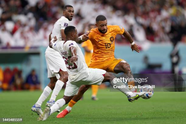 Memphis Depay of Netherlands controls the ball under pressure of Assim Madibo and Abdulaziz Hatem of Qatar during the FIFA World Cup Qatar 2022 Group...