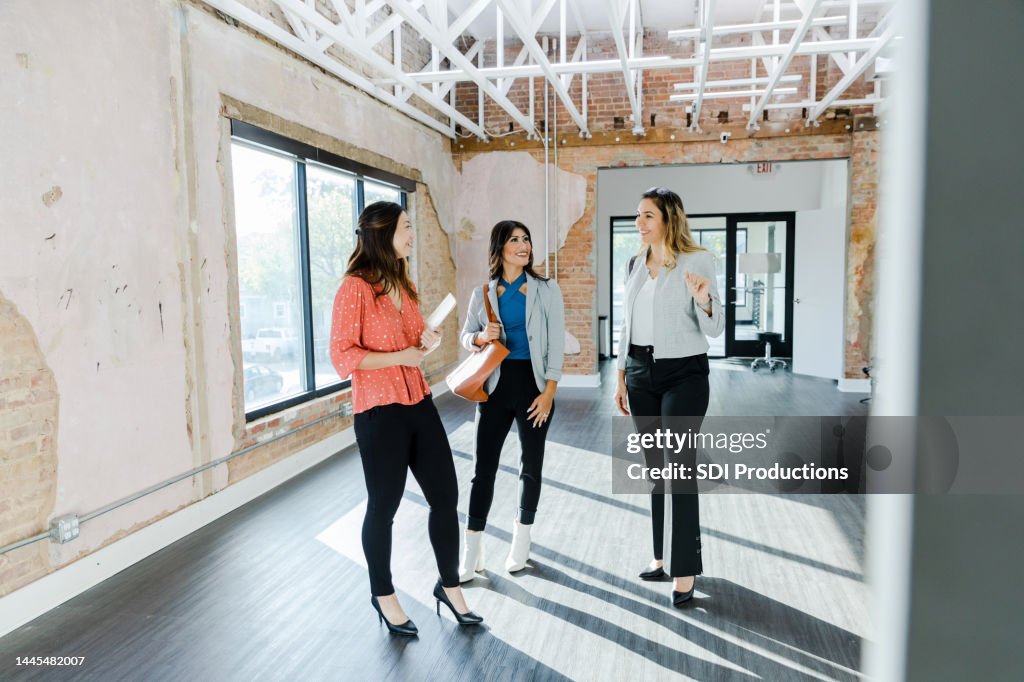 Businesswoman asks female Real Estate Agent questions while touring office space