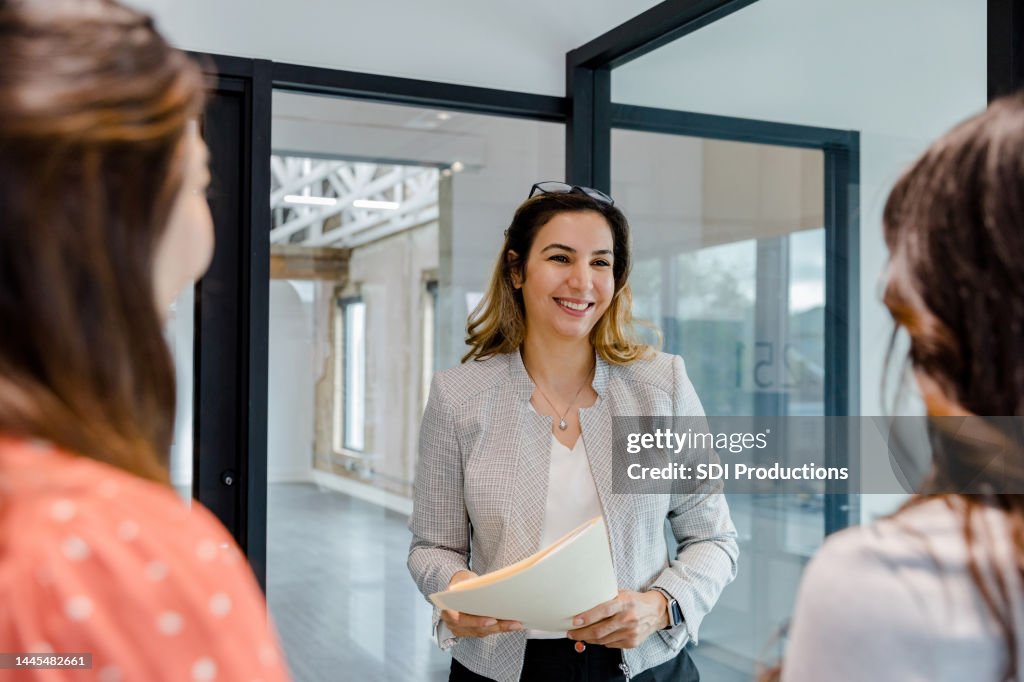 Before showing office loft space, Real Estate Agent chats with businesswomen