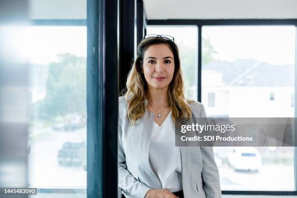 une administratrice se tient près de son bureau pour une photo - conseiller-bancaire photos et images de collection