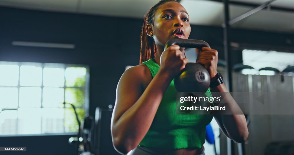 Ejercicio, kettlebell y mujer negra en gimnasio, para fitness y entrenamiento para bienestar, salud y entrenamiento. Niña sana, mujer afroamericana y atleta con equipo para la práctica, cardio o fuerte