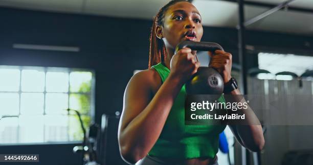 exercise, kettlebell and black woman in gym, for fitness and workout for wellness, health and training. healthy girl, african american female and athlete with equipment for practice, cardio or strong - muscle building stockfoto's en -beelden