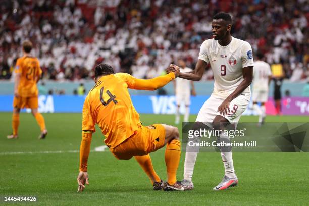 Mohammed Muntari of Qatar helps up Virgil Van Dijk of Netherlands during the FIFA World Cup Qatar 2022 Group A match between Netherlands and Qatar at...