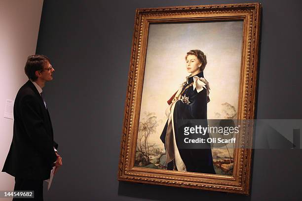 Man views an image of Her Majesty Queen Elizabeth II by artist Pietro Annigoni entitled 'Queen Elizabeth II, Queen Regent' in the National Portrait...