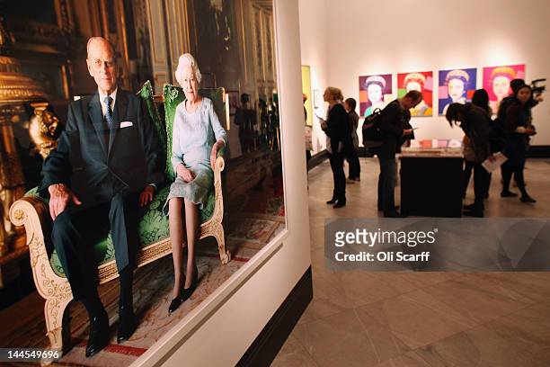 Members of the public view images of Her Majesty Queen Elizabeth II in the National Portrait Gallery's exhibition 'The Queen: Art & Image' on May 16,...