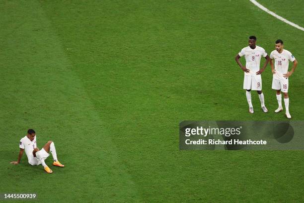 Pedro Miguel, Mohammed Muntari and Boualem Khoukhi of Qatar react after the 0-2 loss during the FIFA World Cup Qatar 2022 Group A match between...