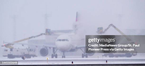 Delta Airlines jet is de-iced at Minneapolis-St. Paul International Airport near St. Paul, Minn. On Tuesday, Nov. 29, 2022. A winter storm is...