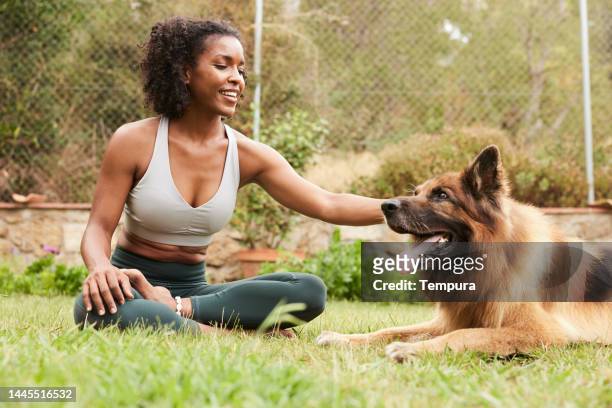 yoga instructor shares a beautiful moment in nature with her german shepherd - german shepherd sitting stock pictures, royalty-free photos & images