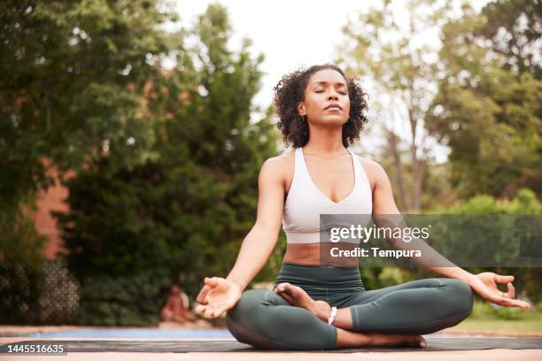 attractive afro-american yoga teacher meditating in lotus pose - self discipline imagens e fotografias de stock