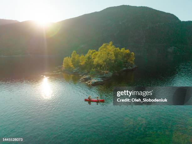 aerial view of man and woman canoeing on the lake in norway - canoe stock pictures, royalty-free photos & images
