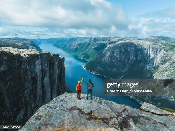 vista aérea de un hombre y una mujer levantados de brazos en montañas en noruega - viajes fotografías e imágenes de stock