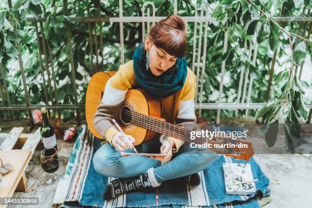 young woman creating new music - martin guitar stock pictures, royalty-free photos & images