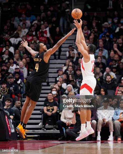Scottie Barnes of the Toronto Raptors shoots against Evan Mobley of the Cleveland Cavaliers during the first half of their basketball game at the...