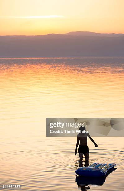 people bathing at sunset, dead sea, jordan - jordan amman stock pictures, royalty-free photos & images