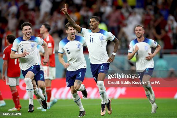 Marcus Rashford of England celebrates with teammates John Stones, Jordan Henderson and Phil Foden after scoring their team's first goal during the...