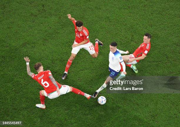 Phil Foden of England controls the ball under pressure of Wales defense during the FIFA World Cup Qatar 2022 Group B match between Wales and England...