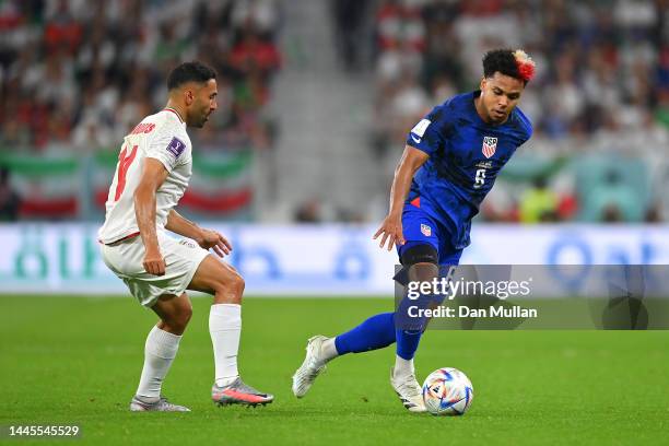 Weston McKennie of United States is challenged by Saman Ghoddos of IR Iran during the FIFA World Cup Qatar 2022 Group B match between IR Iran and USA...