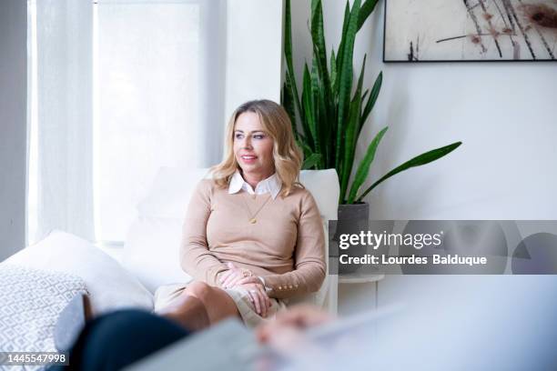 psychological therapy, female psychologist consulting her client during a therapy session - couch interview stock pictures, royalty-free photos & images