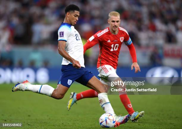 Jude Bellingham of England controls the ball under pressure of Aaron Ramsey of Wales during the FIFA World Cup Qatar 2022 Group B match between Wales...