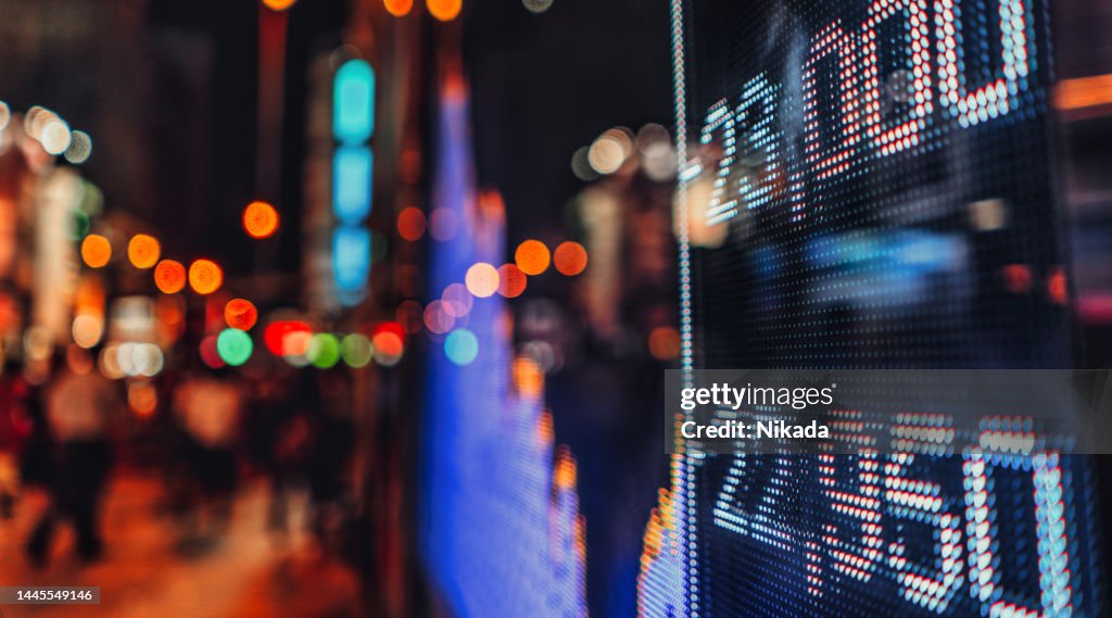 Display of Stock market quotes with city scene reflect on glass