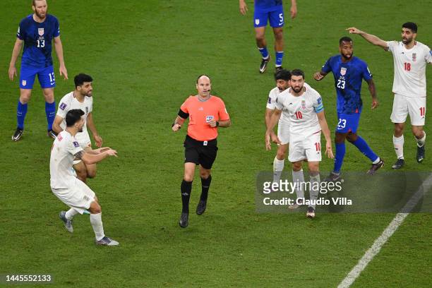 Iran players argue a call with referee Antonio Miguel Mateu Lahoz during the FIFA World Cup Qatar 2022 Group B match between IR Iran and USA at Al...