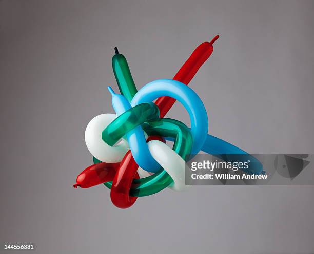 muli-color balloons tied in giant knot - balloon knot stock pictures, royalty-free photos & images
