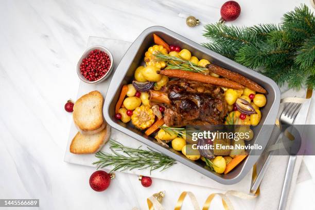 holiday dinner food pork shank with baked potatoes and corn, festive food with christmas new year decor - christmas leg ham stock pictures, royalty-free photos & images