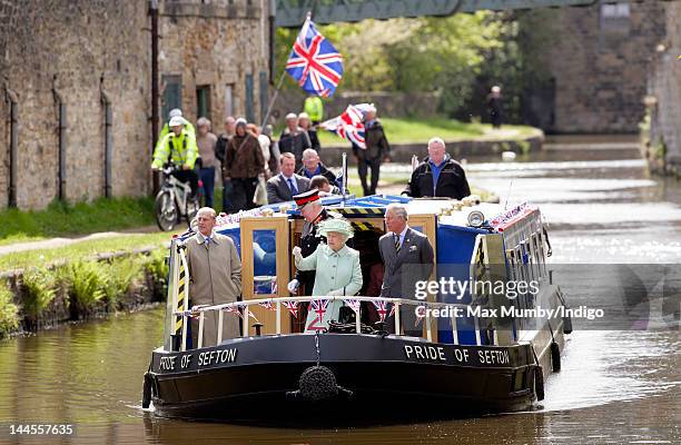 Prince Philip, Duke of Edinburgh, Queen Elizabeth II and Prince Charles, Prince of Wales travel down the Leeds and Liverpool Canal on the 'Pride of...