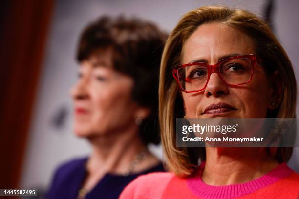 Sen. Kyrsten Sinema looks on as Sen. Rob Portman speaks at a news conference after the Senate passed the Respect for Marriage Act at the Capitol...