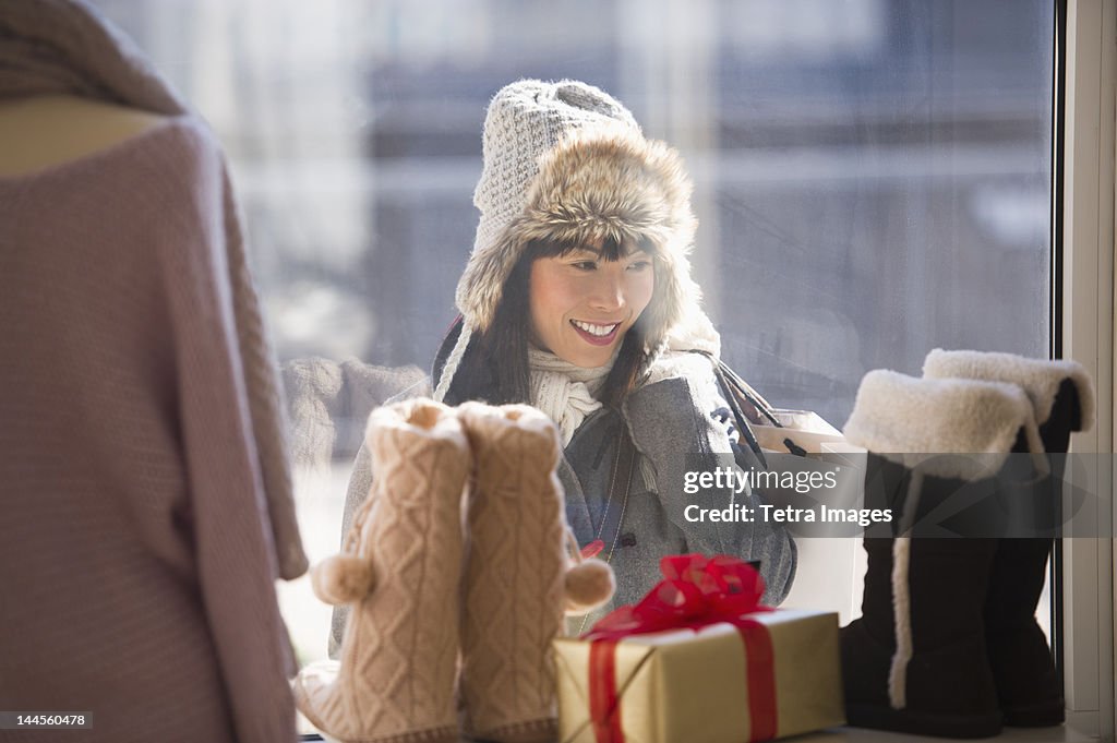 USA, New Jersey, Jersey City, Smiling woman looking at shop display during Christmas shopping