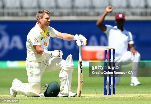 David Warner of Australia and all the players take a knee before the start of play during day one of the First Test match between Australia and the...