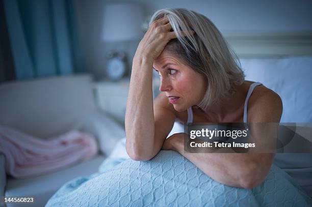 usa, new jersey, jersey city, senior woman sitting in bed and suffering from insomnia - can't sleep stock-fotos und bilder