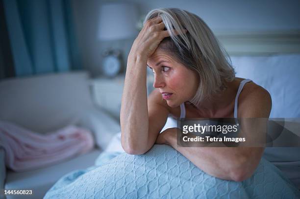 usa, new jersey, jersey city, senior woman sitting in bed and suffering from insomnia - insomnia stock pictures, royalty-free photos & images